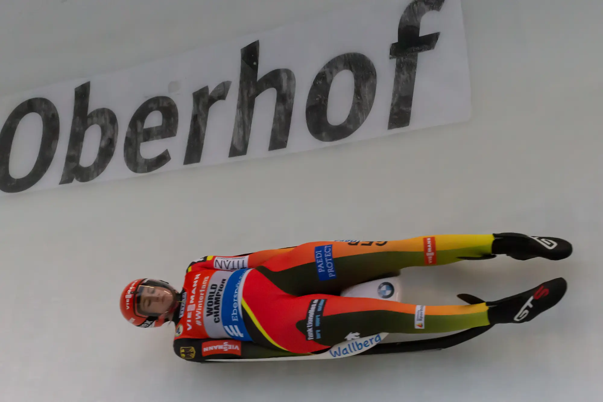 Natalie Geisenberger liegt flach auf ihrem Rennrodel und passiert im Weltcup Oberhof den Schriftzug an der Bahnwand